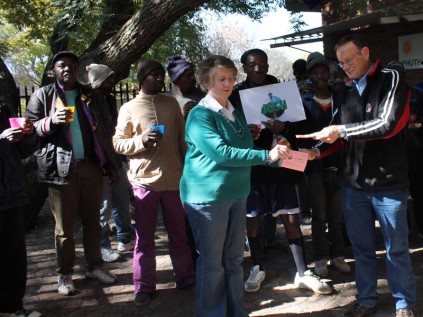 Mike Woods Ward 104 councillor buys the first voucher scheme from Mary Gillett-de Klerk, while some homeless people looked on, at the Randburg Methodist Church on Mandela Day.