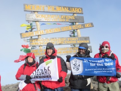 Team reaches the top of the mountain and raise the flag of St Vincent School for the Deaf
